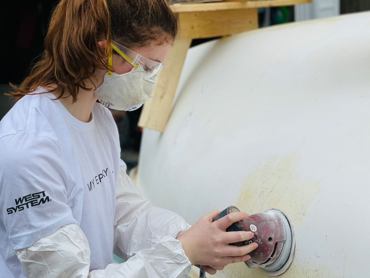 Wetting out fibreglass laminate over a prepared timber surface with WEST SYSTEM epoxy.